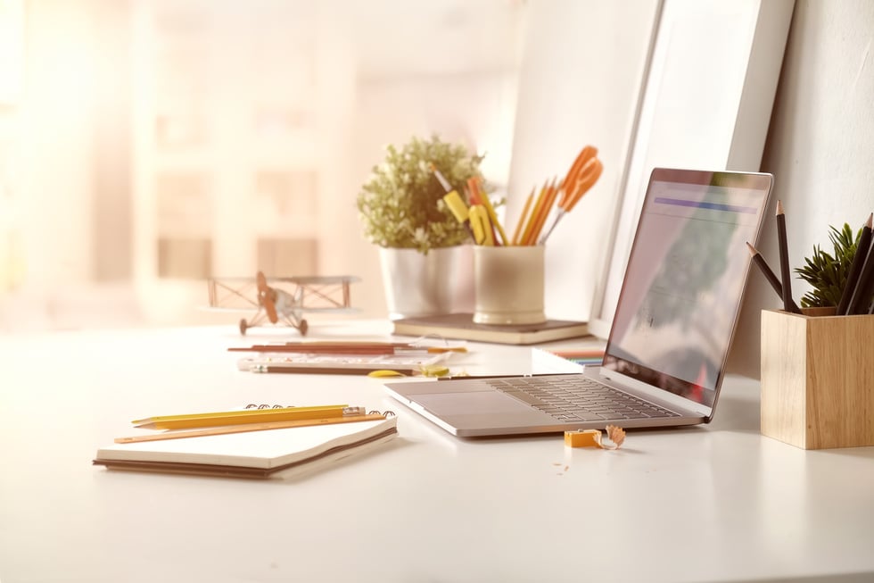 Office desk with laptop computer and business office background.